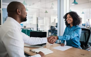 A manager shakes hands with an employee.