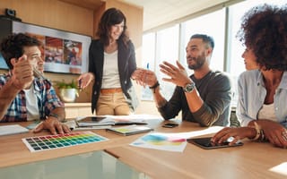 A marketing team discusses something at a table.