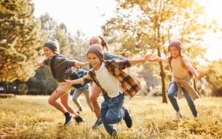 Happy children running outside are pictured.