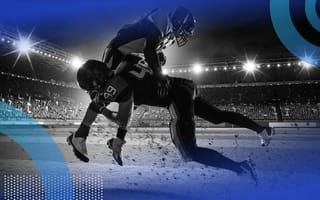 An American football player is being tackled by defense on the field.
