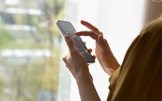 Person’s hands using the touchscreen on a smartphone.
