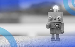 A tiny, retro wooden robot with a lightbulb on its square head.