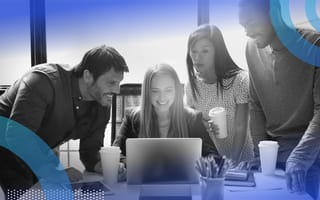 Diverse employees are gathered around a computer screen.