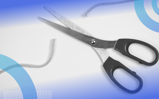 A pair of scissors cutting a string