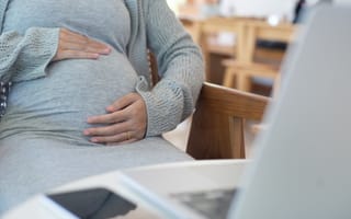 office worker holding their pregnant belly