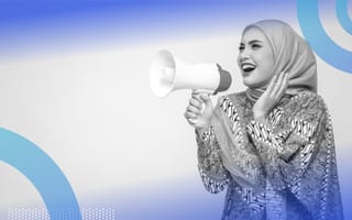 A woman in a headscarf playfully shouting into a microphone toward the side.