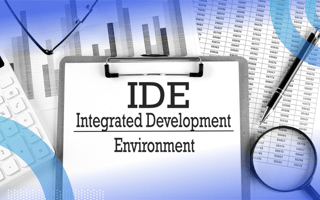 A piece of paper that says “IDE Integrated Development Environment” surrounded by a pen, calculator, magnifying glass and bar graphs on paper.