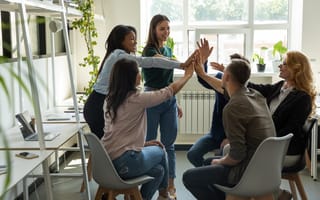 Team members high-fiving each other, celebrating new product launch