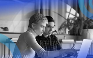 Two women leaders are sitting at a computer and talking.