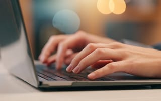 A photo of hands typing on a laptop