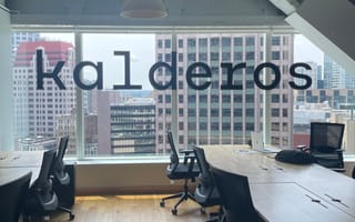 The Kalderos logo in a large window in a conference room overlooking Downtown Boston.
