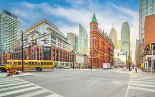 A photo of downtown Toronto. A school bus drives by.
