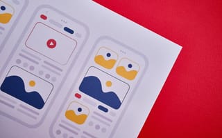 A close up of a paper with app design mockups that include icons representing features like a video player.