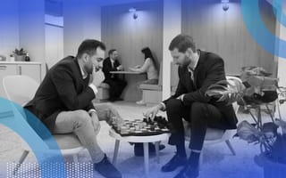 Two men play chess in an office