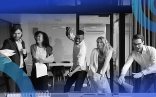 Five salespeople are standing around a table and celebrating a win.