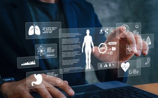 Man on laptop reaching to select floating digital healthcare icon.