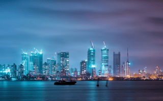 The Mumbai skyline aglow with the lights of the city on a dusky night.