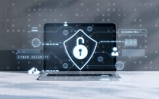 A digital illustration of a padlock and shield are overlaid on top of a laptop computer monitor to represent cybersecurity.