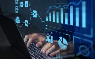 data overlays a hand typing on a computer keyboard
