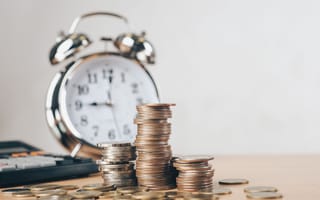 Clock with coins in front of it