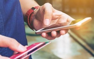 Image of a person holding a phone and a credit card.
