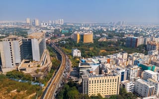 A view of the Hyderabad skyline featuring several tall buildings and a highway.