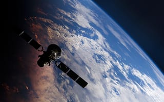A satellite floats in space with a distant view of earth in the background.