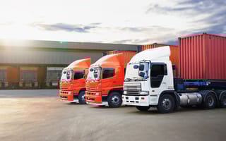 Three freight trucks are parked in a line.