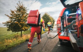 A paramedic rushes from an emergency vehicle.