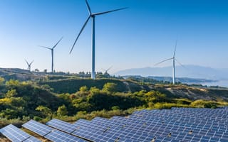 Solar panels and wind turbines in a renewable energy farm.