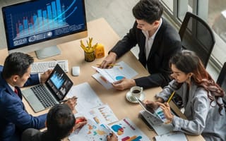 Employes analyze financials with fintech software.