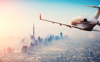 A plane flies over a city.