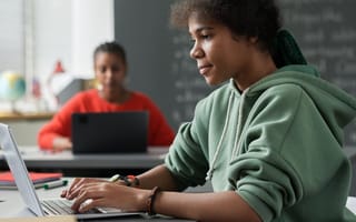 student typing on laptop