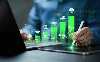 A digital illustration of a green bar graph hovers over a laptop and tablet device.