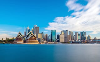 A skyline view of Sydney featuring several skyscrapers behind the Sydney Opera House.