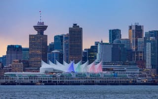 A view of the downtown Vancouver skyline featuring several tall buildings along the water.