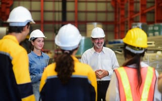 workers in a manufacturing facility gather around to chat