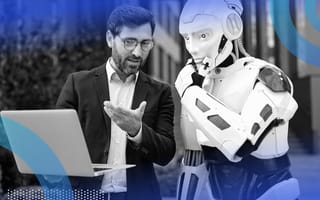A human and robot look at a laptop computer together