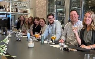 Bounteous’ customer relationship management team members pose for a photo while sharing dinner together at a restaurant.