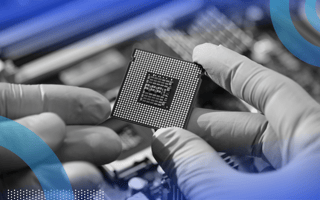Gloved hands hold a computer chip