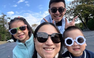 Sukai Qin and her husband and two children, a girl and a boy, take a selfie while wearing sunglasses.