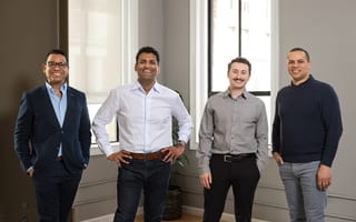 TeamOhana's co-founder poses for a photo with several executives from TeamOhana's customer base.