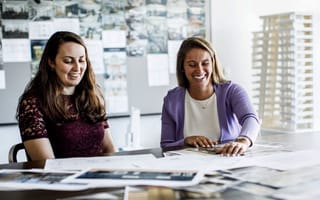 HR business partner Kate Nienaltow sits with a colleague working at a table.
