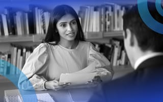 Hiring manager interviewing an applicant and reviewing resumes