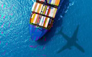 Cargo ship and plane moving products across the water.