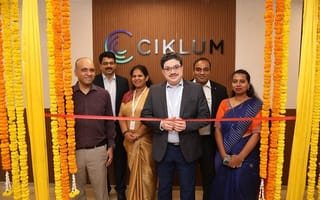 A photo of the Ciklum team at a ribbon cutting ceremony is shown.