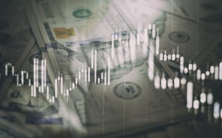 A digital line graph overlays cash to depict financial analytics.