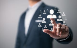 A hand pointing toward a digital icon of a person to depict executive hiring.