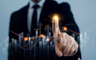 A finger points to a hologram of bar and line graphs representing digital finance growth.