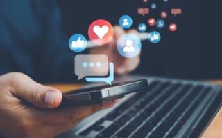 A hand holds a cell phone with icons for messages and social media Social media engagement.